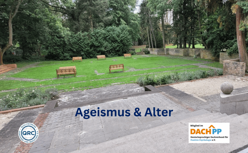 Blick von einer Steinterrasse über Stufen hin auf eine Rasenfläche mich Holzbänken. Auf der unteren Bildhälfte steht mittig "Ageismus & Alter".